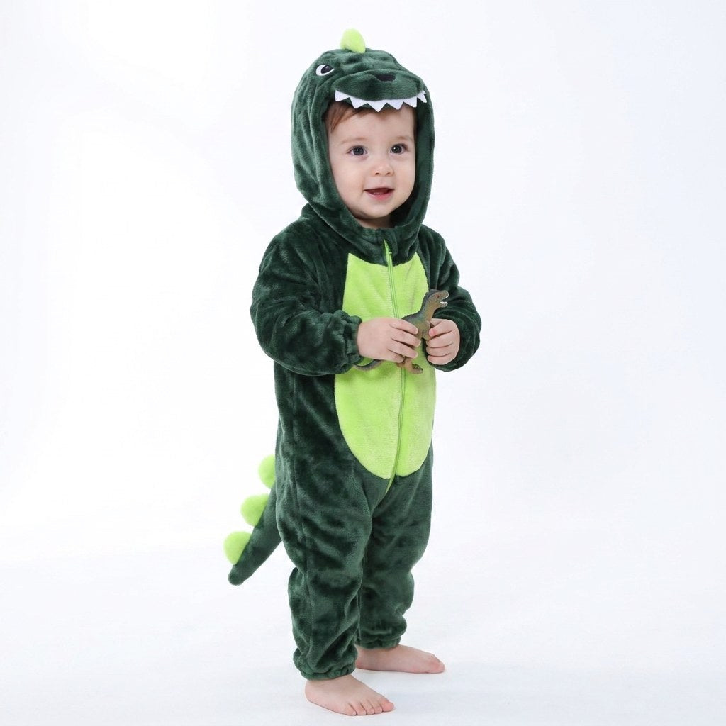 Bébé debout en combinaison dinosaure vert foncé tenant une figurine